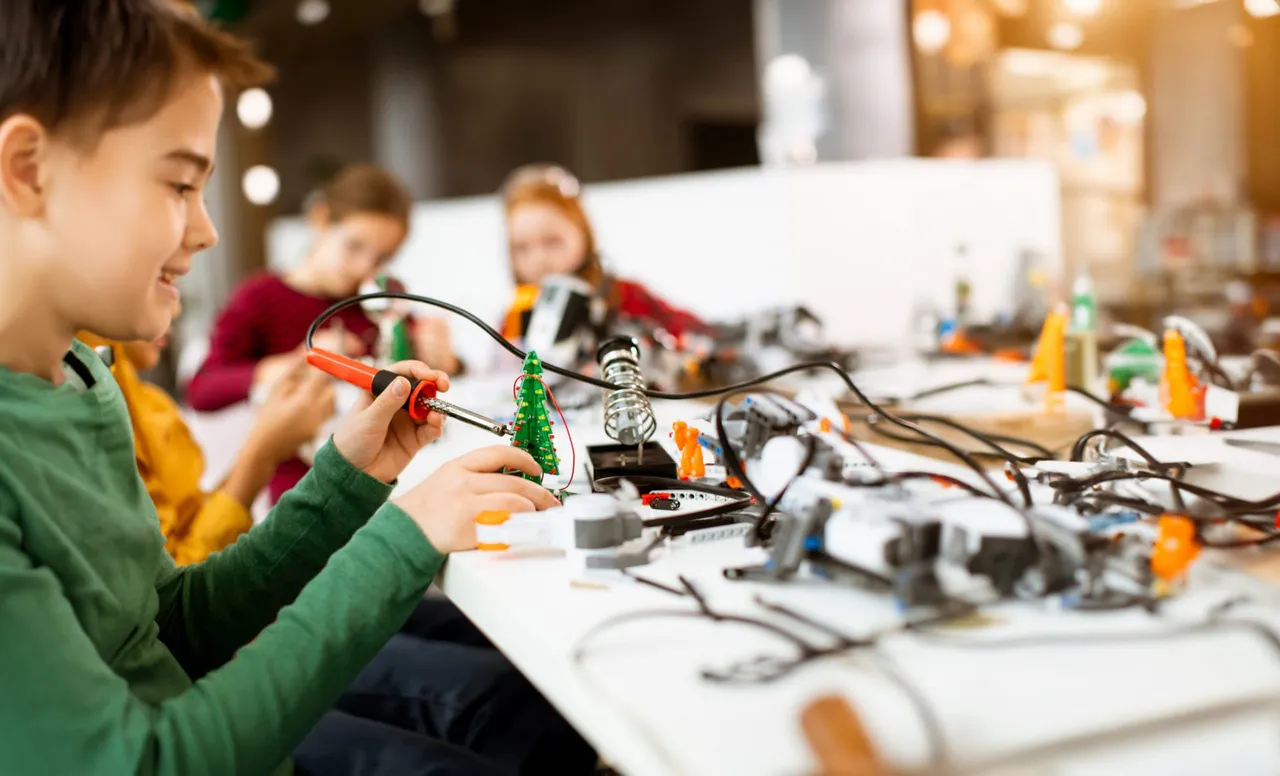 Junge lötet einen leuchtenden Weihnachtsbaum